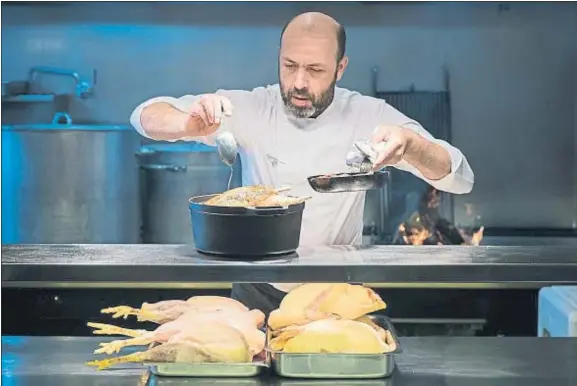  ??  ?? Oriol Rovira. El chef prepara una gallina joven en Els Casals, donde se encuentra la finca donde crían animales