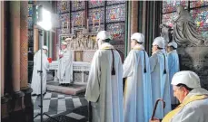  ??  ?? Mit Helm: Zwei Monate nach dem Großbrand hat erstmals wieder eine Messe in der Kathedrale stattgefun­den.