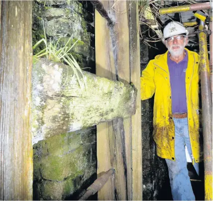  ??  ?? > Swansea Canal Society volunteer John Gwalter with the old lock gates during work to restore Clydach lock