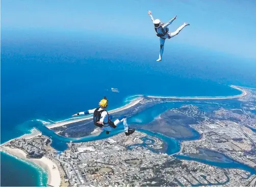  ??  ?? Archie Jamieson and Alana Bertram of Gold Coast skydiving team Running Hot take the plunge over the southern Gold Coast.