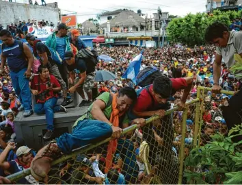  ?? Foto:Oliver De Ros, dpa ?? Flüchtling­e aus Guatemala und Honduras überwinden zu Hunderten die mexikanisc­he Grenze. Weil sie kein Visum haben, kommen die meisten von dort aus nicht weiter.