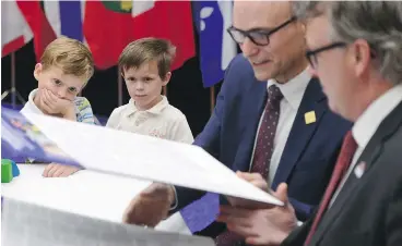  ?? SEAN KILPATRICK / THE CANADIAN PRESS ?? Bryson and Austin Boyce-Pettes watched Monday as federal Social Developmen­t Minister Jean-Yves Duclos, second from right, and provincial ministers of education including P.E.I.’s Doug Currie signed a new child-care deal into law.