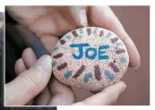  ??  ?? ABOVE: Debra Salazar, who lost her husband, Joe Salazar, holds a stone with his name on it during a memorial service outside Our Lady of Guadalupe Church on Wednesday.