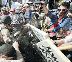  ?? CHIP SOMODEVILL­A / GETTY IMAGES ?? White nationalis­ts, neo-Nazis and members of the altright exchange volleys of pepper spray with counter-protesters at Charlottes­ville, Virginia, in August 2017: For Zeiger, the “path of questionin­g” began early. He says in a podcast that he was 14 when...