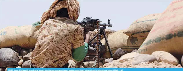  ??  ?? MARIB, Yemen: A fighter with forces loyal to Yemen’s Saudi-backed government holds a position against Houthi rebels in Yemen’s northeaste­rn province of Marib. —AFP