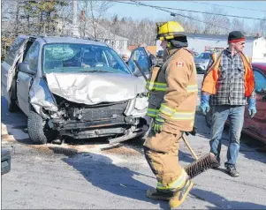  ?? SHARON MONTGOMERY-DUPE/CAPE BRETON POST ?? Members of the Reserve Mines Volunteer Fire Department assisting at a two-vehicle accident at the Gardiner Road Intersecti­on on Seaside Drive on March 4. Members of the Cape Breton Regional Police Service say there were four accidents at this location...