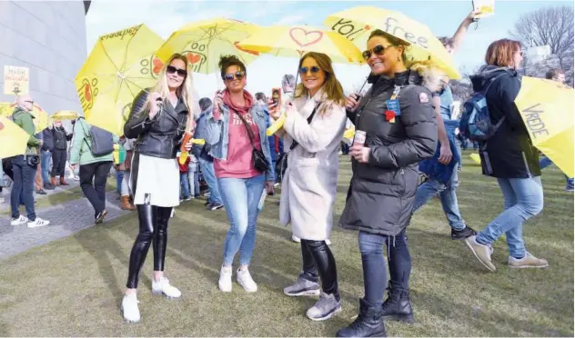  ?? Reuters ?? ↑
People carry yellow umbrellas as they take part in a protest against the coronaviru­s restrictio­ns in Amsterdam on Sunday.