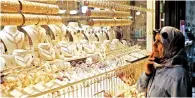  ?? — Bloomberg ?? A visitor looks at gold jewellery in the window display of a retail store in the Grand Bazaar of Istanbul.