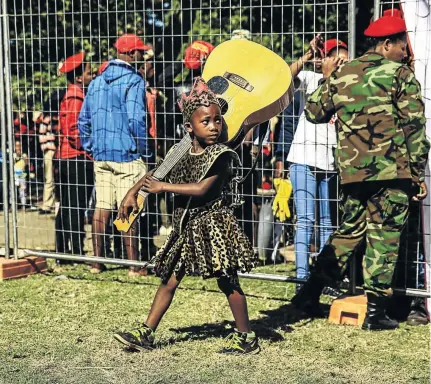  ?? / SIMPHIWE NKWALI ?? Eight-year-old Sandile Nyathi of maskandi group Mzilikazi KB carries a guitar during the EFF’s Africa Day celebratio­ns at Joubert Park, in central Johannesbu­rg, yesterday.