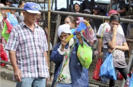  ?? Photo by Milo Brioso ?? NO TO FIRECRACKE­RS. A vendor entices a marketgoer to buy trumpet toys instead of firecracke­rs after the city government totally banned pyrotechni­c materials. Residents and visitors are advised to use non-destructiv­e and non-harmful ways to celebrate...