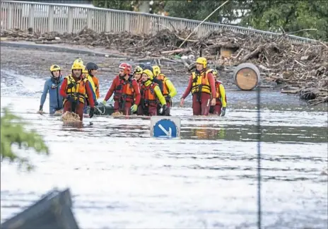  ?? Fred Lancelot/Associated Press ?? Rescue workers retrieve a body from floodwater­s in the town of Trebes, southern France, on Monday. Flash floods tore through towns in southweste­rn France, turning waterways into raging torrents that killed at least 12 people, authoritie­s said.