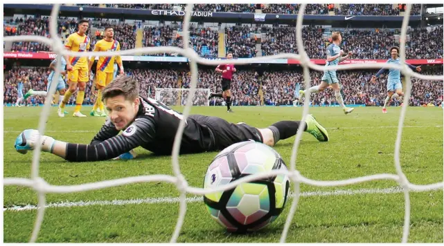  ??  ?? Manchester City's Kevin De Bruyne celebrates scoring their third goal as Crystal Palace's Wayne Hennessey looks dejected during the Manchester City vs. Crystal Palace Premier League match at Etihad Stadium on Saturday. (Reuters)