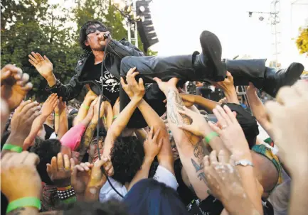  ?? Photos by Santiago Mejia / The Chronicle ?? Seiji of Guitar Wolf crowd-surfs as he performs during the Burger Boogaloo music festival in Oakland.