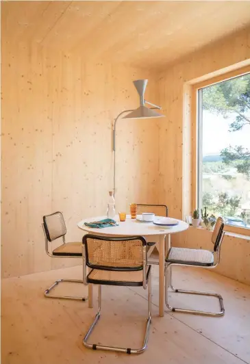  ??  ?? ABOVE A large, low window lets light spill into the dining area, which is furnished with a table by Hay, vintage Cesca chairs by Knoll and a Marseille wall lamp by Le Corbusier. OPPOSITE The generous living space includes (from left) a buffet by...