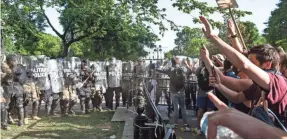  ?? HANNAH GABER/USA TODAY ?? A cadre of law enforcemen­t face off with protesters in Lafayette Square just in front of the White House on Monday.