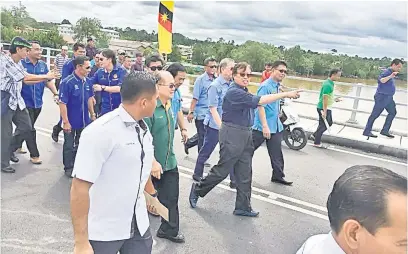  ??  ?? UNTUK RAKYAT: Abang Johari bersama tetamu melakukan tinjauan di atas Jambatan Tandang Sari.