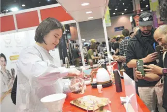  ?? VIOLET MILLER/SUN-TIMES PHOTOS ?? Sherry Hsu, the 2022 World Brewers Cup champion, pours Ethiopian coffee — which she prefers for its hint of blueberry — for attendees at the Specialty Coffee Expo at McCormick Place on Saturday.