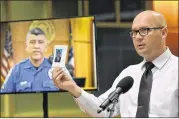  ?? HYOSUB SHIN / HSHIN@ AJC.COM ?? Gwinnett County Police Detective Nermin Cultarevic holds a photo of a suspect as he speaks during a press conference hosted by the Gwinnett County Solicitor’s Office. The event was held to educate the public about fake legal profession­als providing...