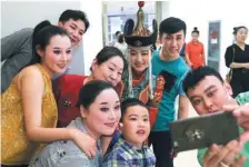  ??  ?? From left: Actors from the musical GrasslandH­eroSisters pose for pictures; a Mongolian wrestling class at Chifeng Mongolian Primary School.