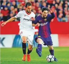  ?? Reuters ?? Barcelona’s Lionel Messi battles with Sevilla’s Franco Vazquez in a La Liga match on Saturday.