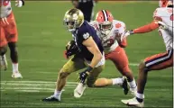  ?? Brian Blanco / Associated Press ?? Notre Dame wide receiver Ben Skowronek (11) evades Clemson defensive tackle Tyler Davis during the ACC championsh­ip game Dec. 19.