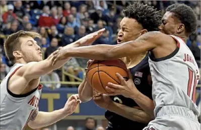  ?? Matt Freed/Post-Gazette ?? Trey McGowens tries to split N.C. State defenders Braxton Beverly and Marshall Johnson.