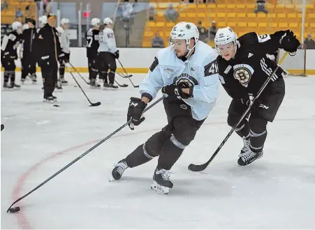  ?? STAFF PHOTO BY NANCY LANE ?? DREAM STILL IN REACH: Martin Bakos controls the puck as he goes through a drill against Karson Kuhlman during Bruins developmen­t camp yesterday at Warrior Ice Arena.