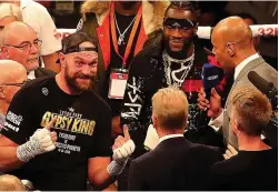  ??  ?? THAT’S ENTERTAINM­ENT:Fury (left) postures for the crowd as Wilder watches on last night