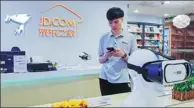  ?? WANG GANG / FOR CHINA DAILY ?? An employee at JD’s first bricks-and-mortar shop in Shanghai.JD will make use of big data analytics technology to keep offline stores stocked with recommende­d categories.