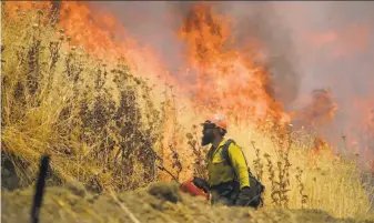  ?? Randall Benton / Sacramento Bee ?? Hot Shot crews from Mendocino use backfires to help contain the County Fire along Highway 128 near Lake Berryessa Tuesday. The fire has burned more than 86,000 acres.