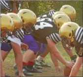 ?? SUBMITTED PHOTO ?? Members of the Roman Catholic football team line up with the ProTech, designed by Defend Your Head, installed over their helmets.