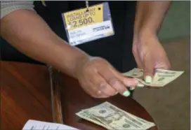  ?? SID HASTINGS — THE ASSOCIATED PRESS ?? In this photo a manager of a financial services store in Ballwin, Mo., counts cash being paid to a client as part of a loan. The firm offers cashbased financial services, including payday loans, installmen­t loans, fund transfers and other financial services. The Consumer Financial Protection Bureau will revisit a crucial part of the bureau’s year-old payday lending industry regulation­s, the bureau announced Friday.