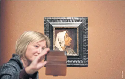  ??  ?? LEFTA visitor takes a selfie with the Head Of A Peasant Woman during the opening of the exhibition of the Flemish painter Pieter Bruegel the Elder at the Kunsthisto­risches Museum in Vienna, Austria.