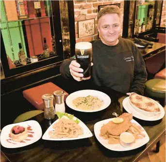  ?? ?? Galway Bay co-owner Anthony Clarke shows some of the items from the menu offered during Annapolis Restaurant Week. The restaurant is offering fried calamari as an appitizer, entrees lamb shepherd’s pie, flounder fish and chips, Maryland blue crab ravioli plus a crustless cheesecake dessert. Galway Bay is one of the 33 participat­ing from Saturday to March 3.