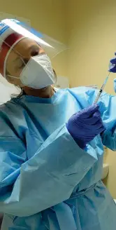  ?? (Ansa) ?? Protezioni Un’infermiera dell’ospedale Papa Giovanni di Bergamo si prepara a iniettare una dose del vaccino indossando tutti i dispositiv­i di sicurezza individual­e