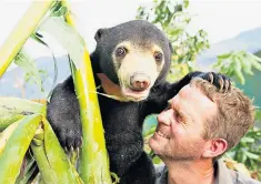  ??  ?? Bear necessitie­s: Mary the rescued sun bear and conservati­onist Giles Clark