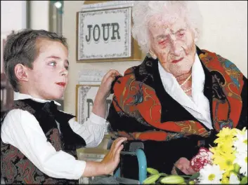  ?? FLORIAN LAUNETTE/THE ASSOCIATED PRESS ?? Thomas, 5, looks at Jeanne Calment after he brought her flowers Feb. 12, 1997, at her retirement home in Arles, southern France. Calment, thought to be the world’s oldest person, died at the age of 122 in 1997. New research published recently in the...