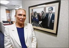  ?? PHOTO COURTESY OF THE BLADE ?? Lucas County Prosecutor Julia Bates in front of a photo hanging on the Lucas County Prosecutor’s Office wall from the Cook brothers case in 2000 in Toledo on Jan. 29. “We could never prove the other cases,” she said.