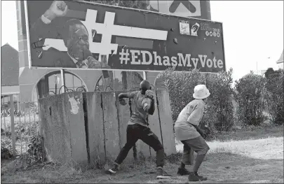  ?? TSVANGIRAY­I MUKWAZHI/ AP PHOTO ?? An opposition party supporter throws a rock aimed at Zimbabwean President Emmerson Mnangagwa’s election campaign poster in Harare, Zimbabwe on Wednesday.