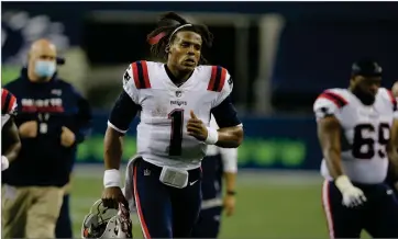  ?? AP PHOTO BY JOHN FROSCHAUER ?? New England Patriots quarterbac­k Cam Newton jogs off the field after an NFL football game against the Seattle Seahawks, Sunday, Sept. 20, 2020, in Seattle. The Seahawks won 35-30.