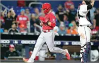  ?? LYNNE SLADKY / AP ?? Los Angeles Angels’ Michael Stefanic scores past Miami Marlins catcher Jacob Stallings on a sacrifice fly by Taylor Ward during the ninth inning of a baseball game on Tuesday in Miami.