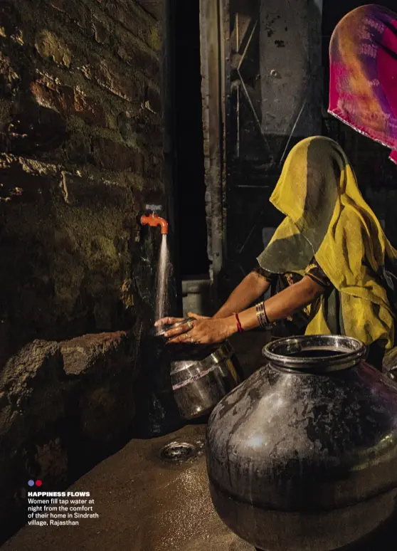  ??  ?? HAPPINESS FLOWS
Women fill tap water at night from the comfort of their home in Sindrath village, Rajasthan