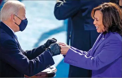  ??  ?? SUCKING UP TO THE LEFT: Joe Biden fist bumps Kamala Harris after she was sworn in as his deputy