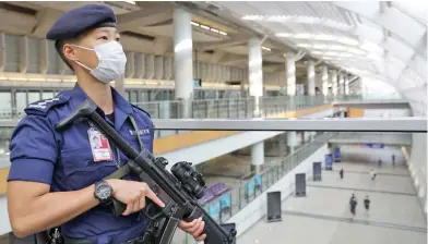  ??  ?? Hung Yat Na, Chief Inspector of the Airport Security Unit under the Hong Kong Police Force, patrols at the Hong Kong Internatio­nal Airport on May 14, 2020.