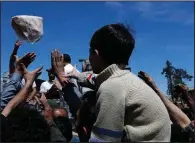  ?? AP/HASSAN AMMAR ?? Syrian authoritie­s pass out bread Monday in the town of Douma, the site of a suspected poison gas attack earlier this month.