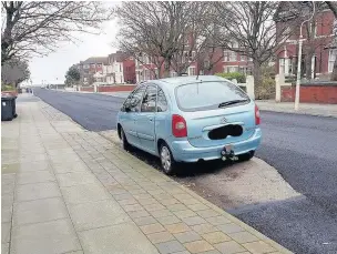  ??  ?? The car with exposed old road surface after asphalt was laid around it