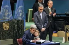  ?? THE ASSOCIATED PRESS ?? U.S. Secretary of State John Kerry holds his granddaugh­ter as he signs the Paris Agreement on climate change Friday at U.N. headquarte­rs.