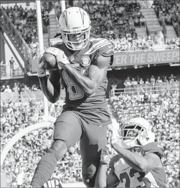  ?? Robert Gauthier Los Angeles Times ?? MIKE WILLIAMS of the Chargers hauls in a pass from Philip Rivers for a touchdown over Arizona cornerback Bene Benwikere. Williams had touchdown receptions of nine and two yards, both in the second quarter.