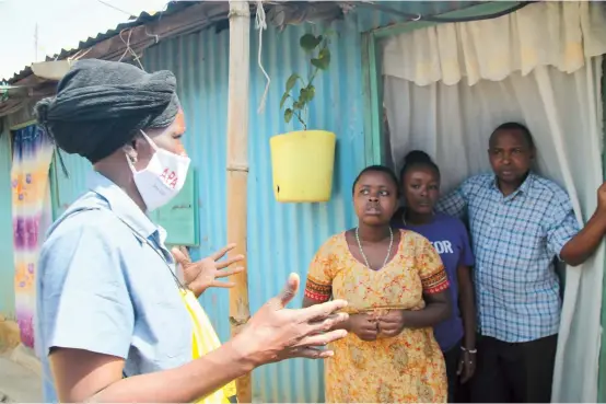  ??  ?? Community health volunteer Everlyne Akinyi Omondi (left) talks to residents about the dangers of COVID-19 in Kawangware informal settlement in Nairobi, Kenya. — Reuters