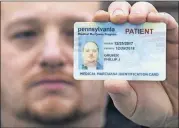  ?? [MATT ROURKE/THE ASSOCIATED PRESS] ?? Phil Gruver poses for a photograph Wednesday with his Pennsylvan­ia medical marijuana card in Emmaus, Pa. As gun-loving Pennsylvan­ia becomes the latest state to operate a medical marijuana program, authoritie­s are warning patients that federal law bars...